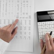 Woman using a calculator and points her finger at the numbers in the financial documents. Financial,business and money concept.